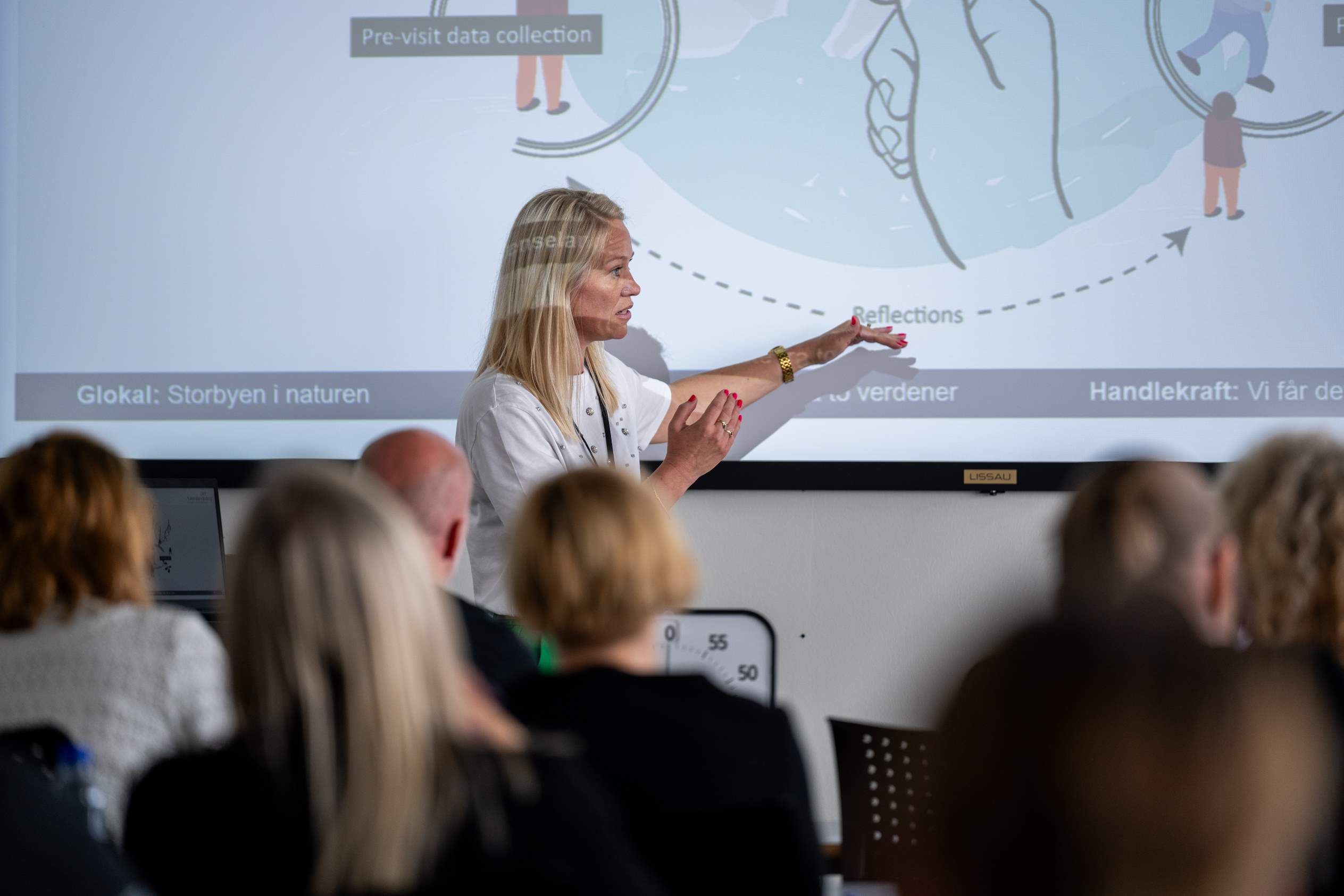 Marie Fink peger på en skærm under et oplæg for en gruppe