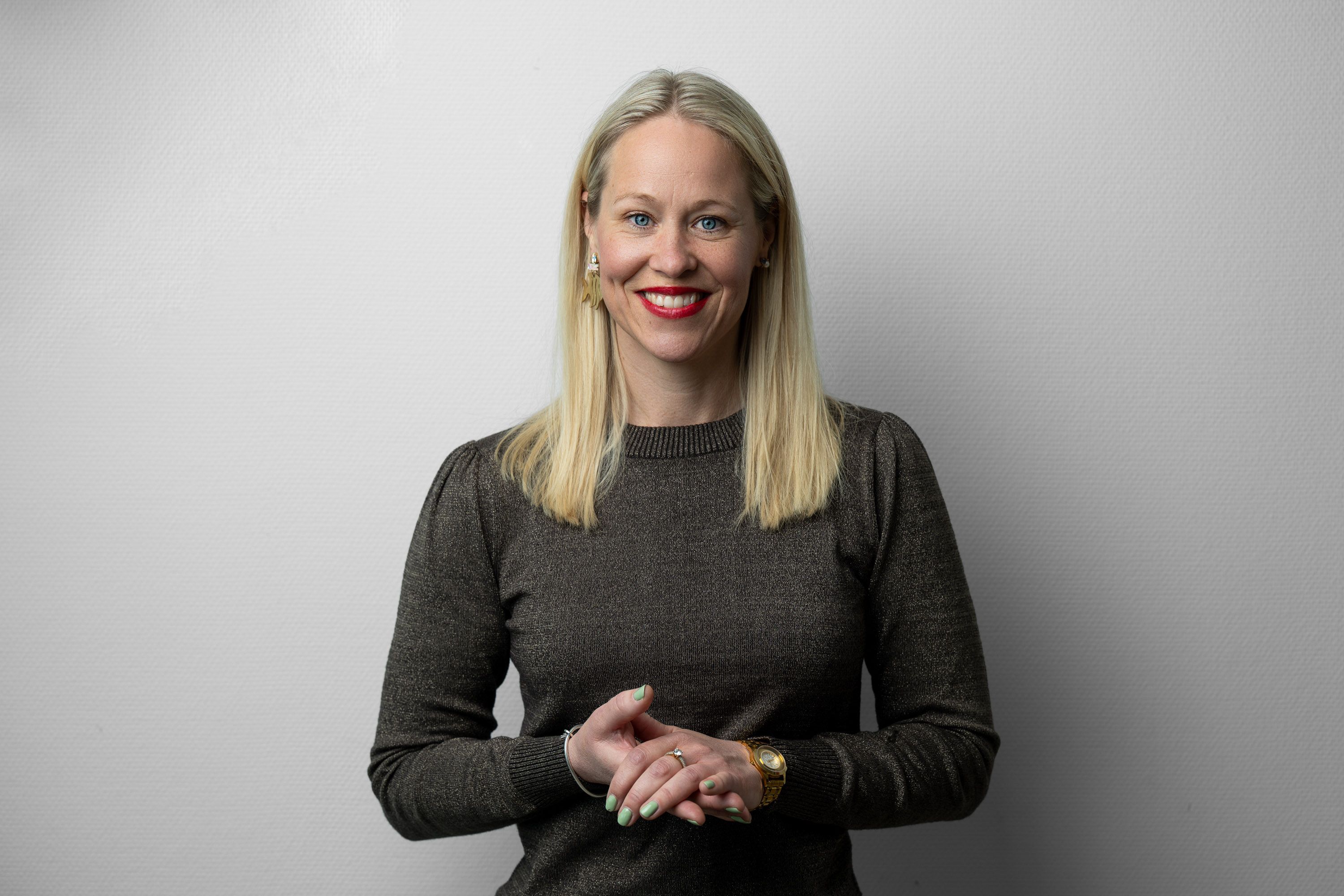 Ledercoach Marie Fink i grå strik mod en lys væg